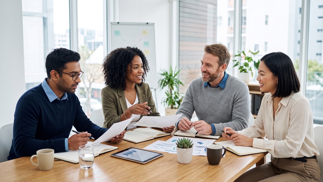 A team of colleagues discussing paperwork around a table