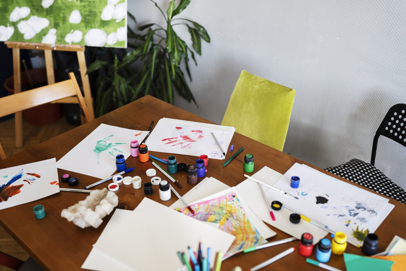 A craft table set up with paints and artwork for creative activities